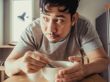 Adam kahvaltı Mısır gevreği sıkıcı bir bolw yaşıyor.