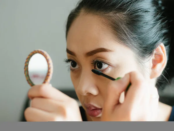 Женщина наносит макияж на ресницы . — стоковое фото