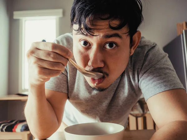 O homem está a comer cereais chatos ao pequeno-almoço. . — Fotografia de Stock