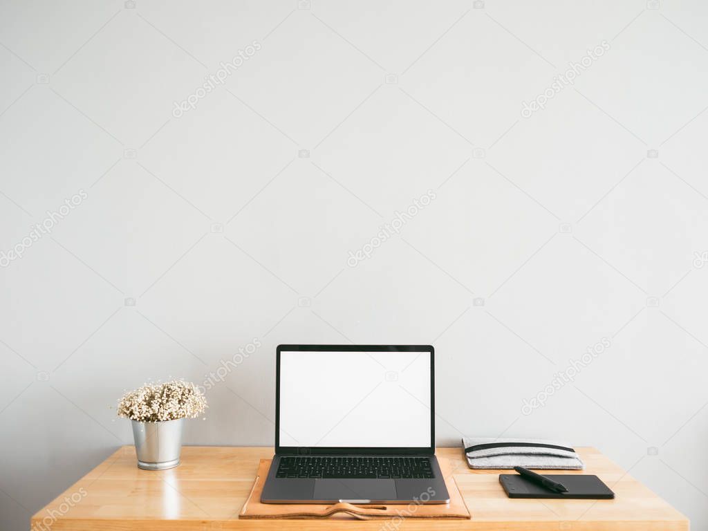 Laptop and some stationary tools on wooden work desk with empty 