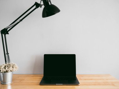 Laptop ve boş ahşap çalışma masası üzerinde sabit bazı araçlar 