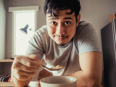 Adam kahvaltı Mısır gevreği sıkıcı bir bolw yaşıyor.