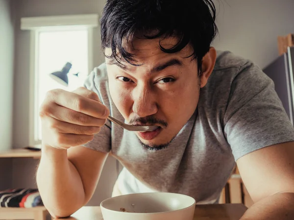 O homem está a comer cereais chatos ao pequeno-almoço. . — Fotografia de Stock