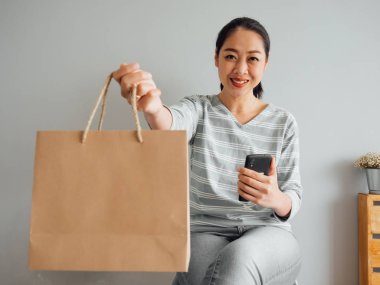 Kadın bağlantılı satın alınan ürün boş kağıt torba gösterilen