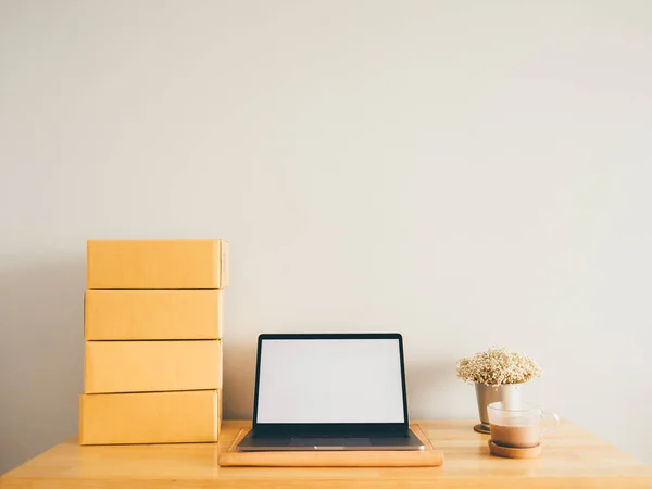 Burla de blanco portátil pantalla vacía con cajas en la mesa. Concep — Foto de Stock