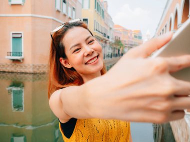 Kadın turist selfie fotoğraf--dan belgili tanımlık smartphone alıyor.