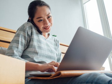 Mutlu Asyalı kadın online mağaza sahibi müşteriden sipariş almak. Online mağaza dijital iş sahibi kavramı.