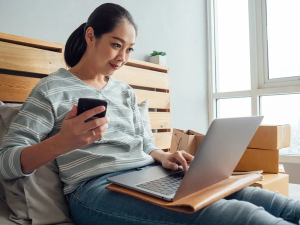 Happy Asian woman online store owner receiving order from customer. Concept of online store digital business owner.