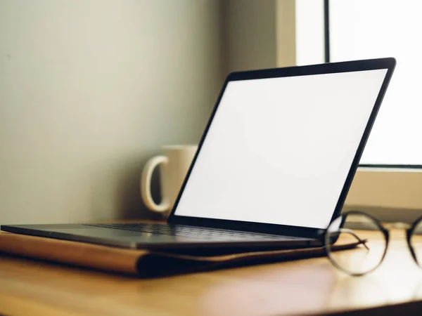 Laptop met leeg scherm op houten bureau in de kamer van freelance — Stockfoto