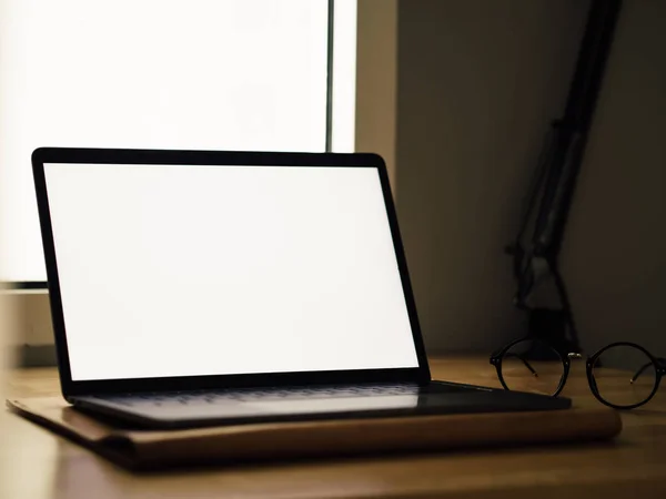 Laptop med tom skärm på trä skrivbord i rummet av frilans — Stockfoto