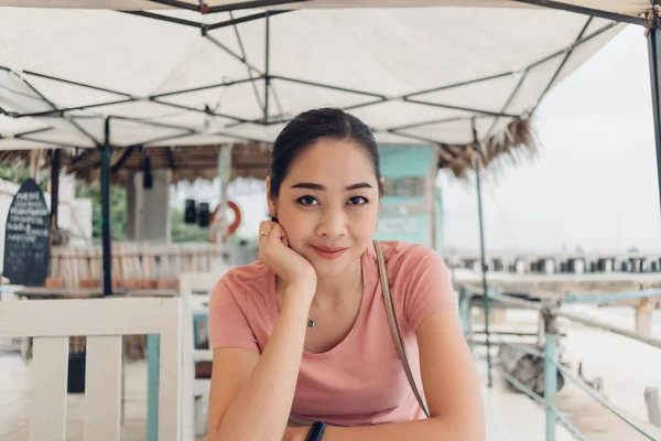 Ευτυχισμένη γυναίκα κάθεται στο εστιατόριο στην παραλία. — Φωτογραφία Αρχείου