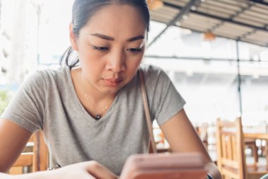 Kadın ciddi yüzlü akıllı telefon kullanıyor..