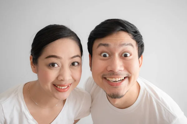 Surpreso com o rosto engraçado casal em t-shirt branca e fundo branco . — Fotografia de Stock