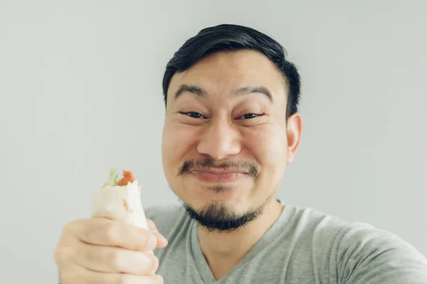 Funny face man selfie himself eating homemade chicken kebab.