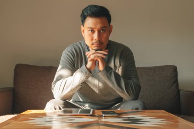 Adam oturma odasında akıllı tablet cihazını kullanıyor..