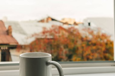 Cup of coffee at the edge of the windows in the morning.