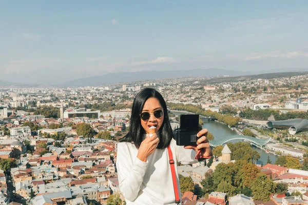 Aziatisch vrouw toerist is het nemen van selfie van zichzelf met landschap uitzicht op Tbilisi, Georgië. — Stockfoto