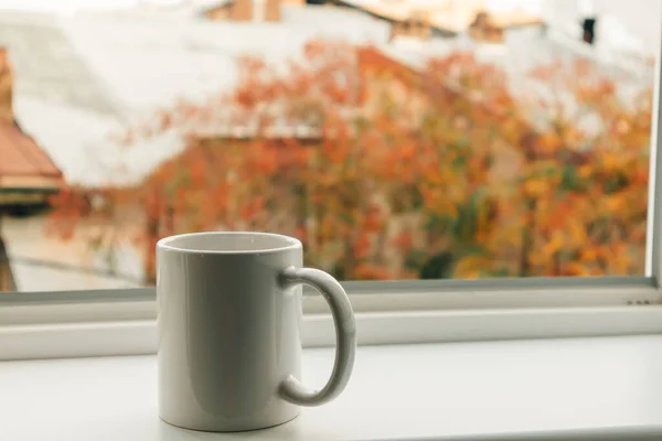 Cup of coffee at the edge of the windows in a warm morning.