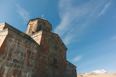 Gergeti Trinity Kilisesi da bir dağ sırtı ve bulutlar, Stepantsminda, Kazbegi, Gürcistan arka plan üzerinde Tsminda Sameba bilinen.