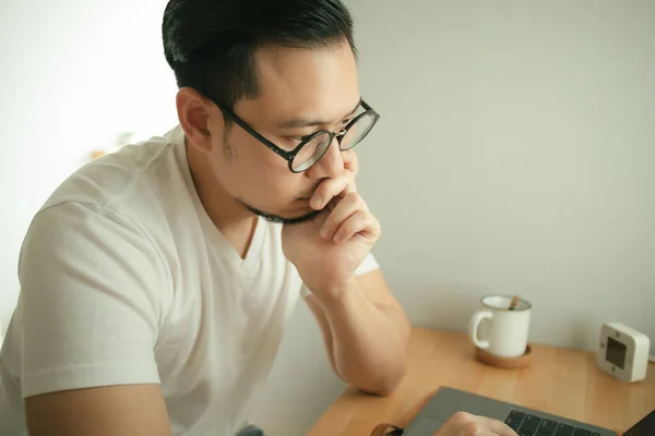 El hombre está trabajando con el ordenador portátil en su apartamento en concepto de Trabajo Desde Casa . — Foto de Stock