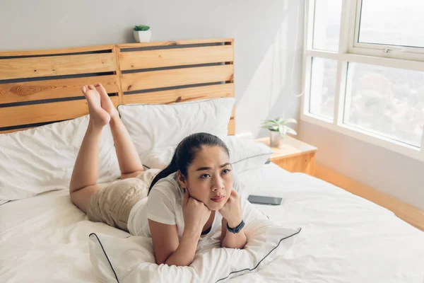 Femme est couchée sur le lit et regarder sérieusement série télévisée dramatique . — Photo