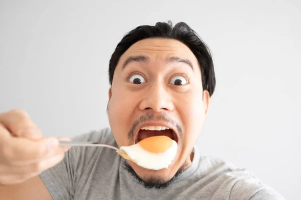 Faccia divertente di uomo mangia l'uovo fritto per proteina . — Foto Stock