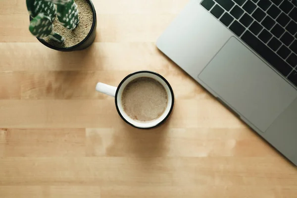 Arbeitsplatz mit Laptop und Kaffeetasse auf Holzschreibtisch. — Stockfoto