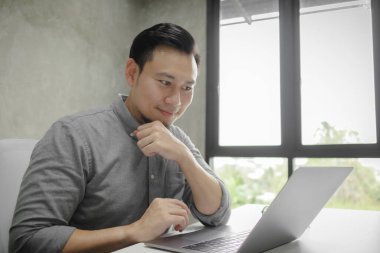 Dizüstü bilgisayarda tek başına çalışan adamın mutlu yüzü..