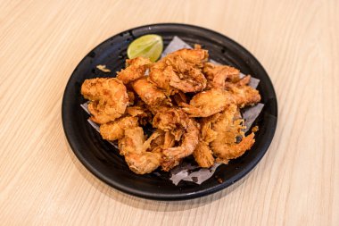 Kızarmış karides yanında servis edilir..