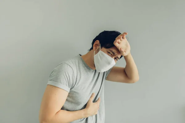 Хворий чоловік у білій гігієнічній масці в сірій футболці в концепції вірусу . — стокове фото