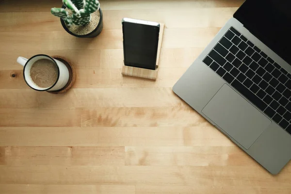 Arbetsplats med laptop och kaffekopp på träbord. — Stockfoto