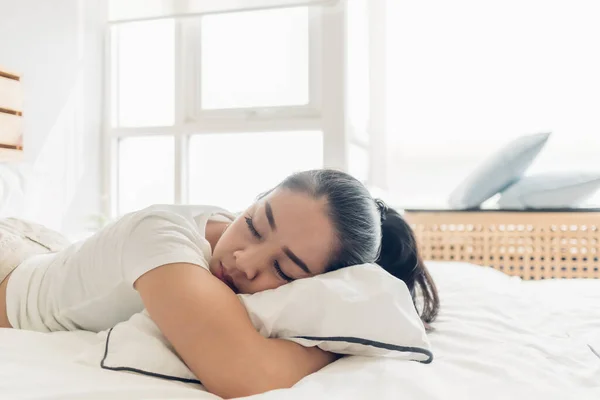 Woman is sleeping on her white bed in the apartment. — Stock Photo, Image