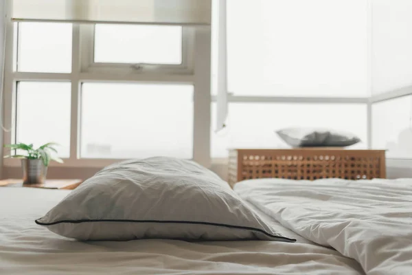 Parlak gün ışığında konforlu beyaz yatak odası. — Stok fotoğraf