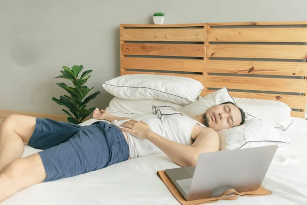 Sleepy vago hombre está trabajando desde casa, pero dormir en frente de la computadora portátil . — Foto de Stock