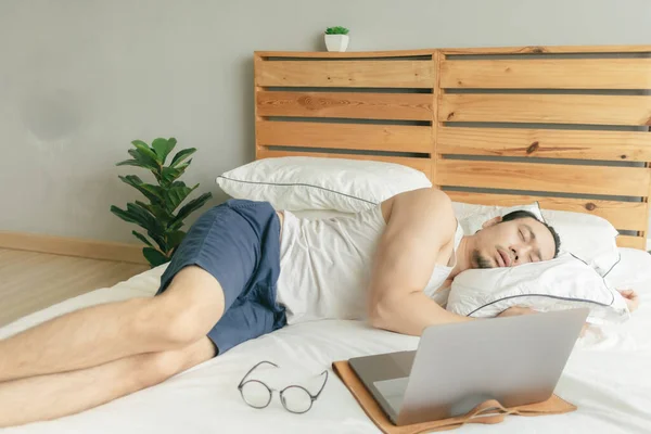 Sleepy vago hombre está trabajando desde casa, pero dormir en frente de la computadora portátil . — Foto de Stock