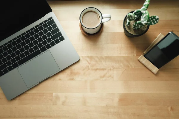 Arbeitsplatz mit Laptop und Kaffeetasse auf Holzschreibtisch. — Stockfoto