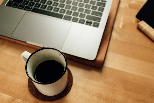 Kaffee und Laptop auf dem Tisch im Konzept der Arbeit von zu Hause aus. — Stockfoto