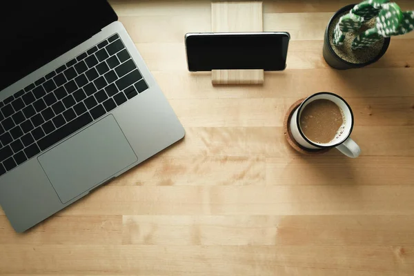 Area kerja dengan laptop dan cangkir kopi di meja kayu. — Stok Foto