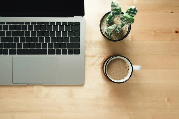 Espaço de trabalho com laptop e xícara de café na mesa de madeira . — Fotografia de Stock