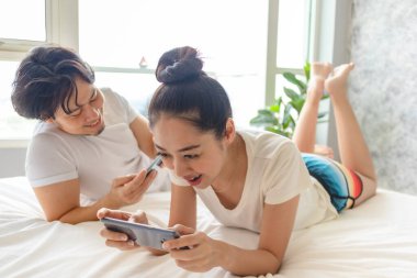 Mutlu çift yataklarında mobil oyun oynuyor..