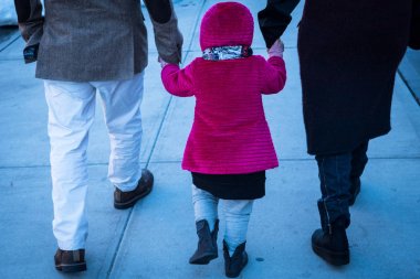 New York'ta kaldırımda ailesi ile el ele tutuşarak çocuk