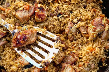 Yaban mersini, sığır eti ve gümüş kaşıkla yanıyor bir kazan içinde havuç pirinç