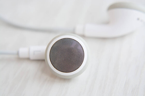 Headphones for Iphone white on white wooden desk close-up