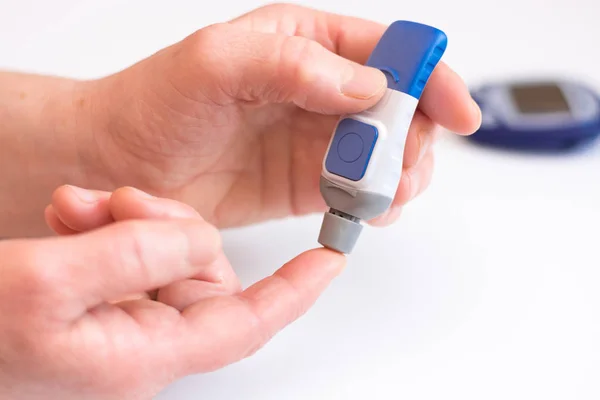 Diabetes gör blod glukos mätning. Kvinna med hjälp av lancet och Glukometer. — Stockfoto