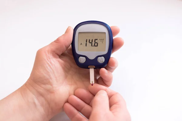 Nära person kontrollera blodsocker med glukometer och testremsa hemma — Stockfoto