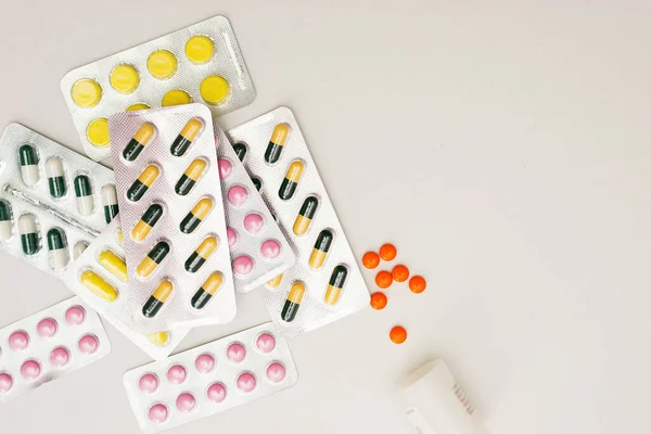 Montón de píldoras médicas en colores amarillo, rosa y verde. Pastillas en envase de plástico . Fotos De Stock