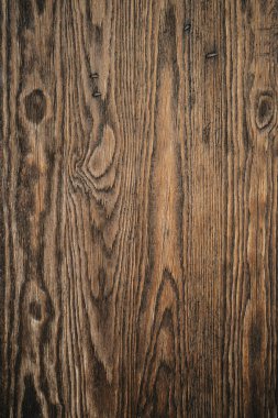 Kahverengi doğal organik ahşap dokusuyla yakın plan. Tahta bir tahtanın yüzeyinde farklı şekiller, düz ve eğri çizgiler.