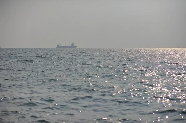 Barco en la superficie del mar y reflejo del sol — Foto de Stock