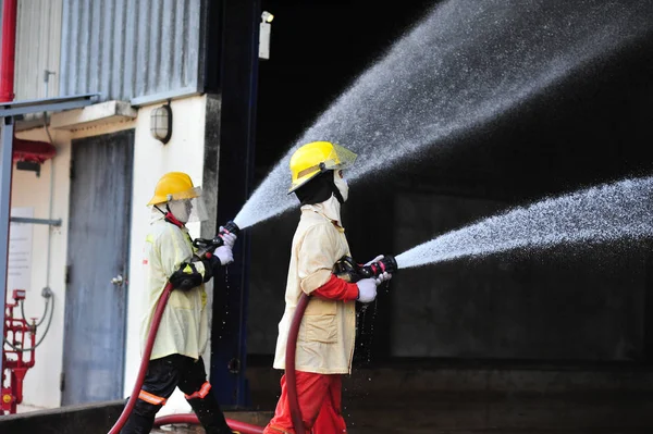 Gruppo di vigili del fuoco uomo sono iniettare spruzzare l'acqua per sparare acc — Foto Stock