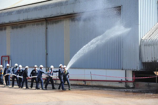 Grupo de bomberos hombre se inyectan rociar el agua para disparar acc Imagen de archivo